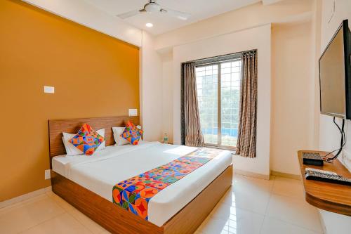 una camera da letto con un letto grande e una finestra di FabHotel 24 Baner - Nr MCF Camp a Pune