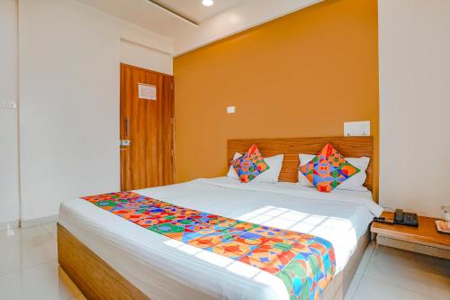 una camera da letto con un grande letto con lenzuola e cuscini colorati di FabHotel 24 Baner - Nr MCF Camp a Pune