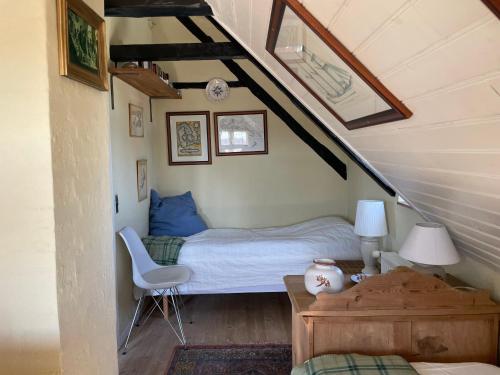 a bedroom with a bed and a chair in a attic at Bjergly in Hjørring