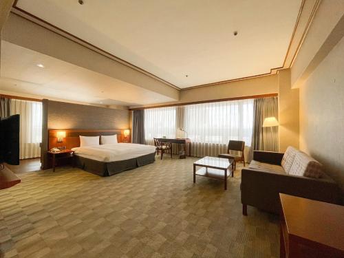 a large hotel room with a bed and a couch at Guide Hotel Hsinchu Zhongyang in Hsinchu City