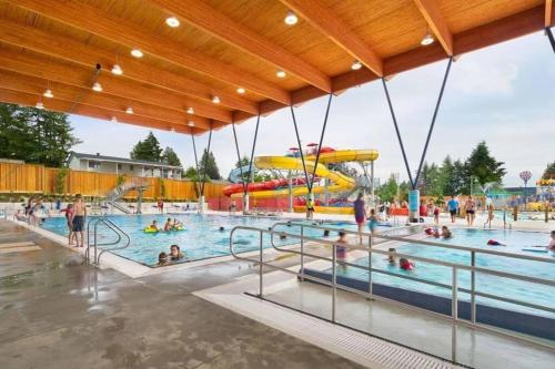 a water park with a pool with people in it at Brand New 2 Bedroom Suite in Langley Twp - Play Area, Patio & Mini Golf in Aldergrove