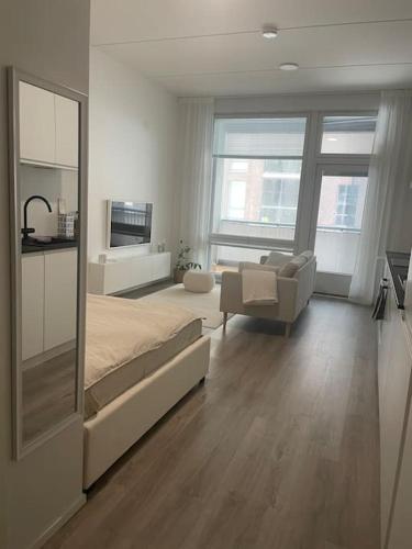 um quarto com uma cama grande e uma sala de estar em Yksiö loistavalla sijainnilla sekä yhteyksillä em Vantaa