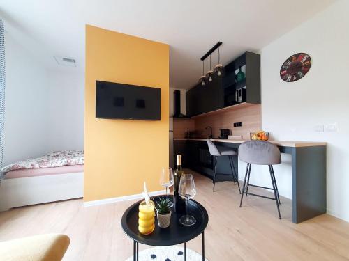 sala de estar con mesa pequeña y cocina en StudioApartman M en Valpovo