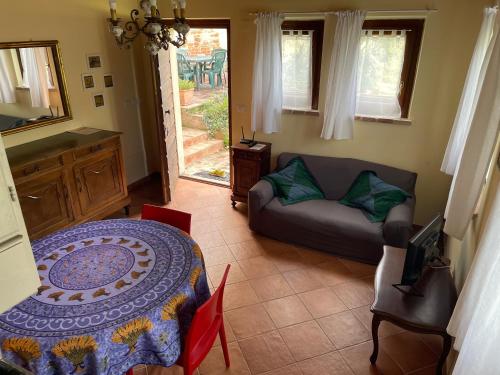 a living room with a table and a couch at Al Giardino Degli Etruschi in Chiusi