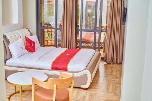 a hotel room with a bed and a table and chairs at Wilsen Hotel Nansana in Kampala