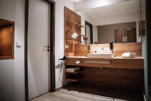 a bathroom with a sink and a mirror at Centrale Hotel und Restaurant in Waldkraiburg