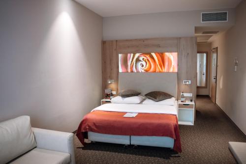 a hotel room with a bed and a couch at Centrale Hotel und Restaurant in Waldkraiburg