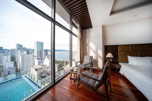 a bedroom with a bed and a large window with a pool at Green Beach Nha Trang in Nha Trang