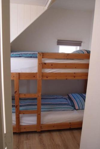 two bunk beds in a room with a staircase at Have a nice stay! - Zomerhuis Toda Cambia dicht bij strand in Noordwijk aan Zee