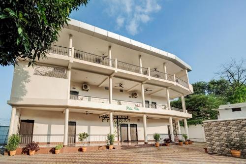 un gran edificio blanco con balcones y plantas en Super Capital O Gulmohar Marriage Garden, en Dhanbād