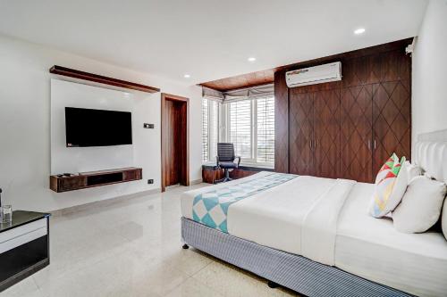 a bedroom with a large bed and a flat screen tv at Sayhallo Prime Residency in Bhubaneshwar