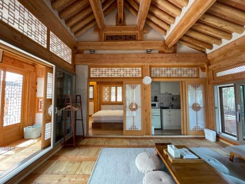 a living room with wooden ceilings and a bedroom at Hanok Stay - JukRokJungSa in Gurye