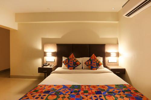 a bedroom with a bed with two night stands and lamps at FabHotel West Inn in Mumbai