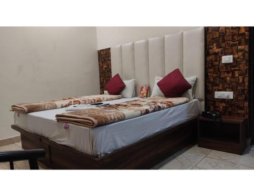 a bedroom with a large bed with red pillows at Hotel Mayur Classic, Ludhiana in Ludhiana