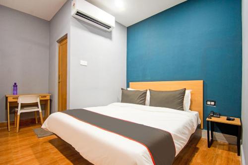 - une chambre avec un grand lit et un mur bleu dans l'établissement Super Collection O Sayhallo Hillside Magnum, à Khandagiri