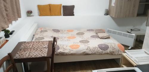 a small bedroom with a bed and a table at Petkovic Apartmani 3 in Tivat