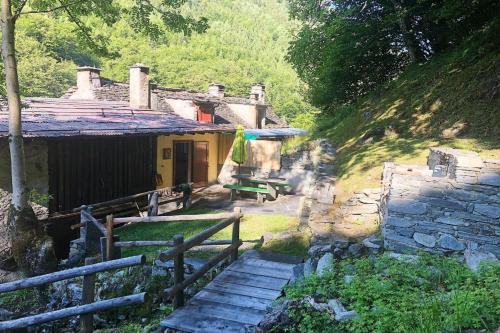 a small house with stairs leading up to it at Spitzenhaus Val Onsernone - Happy Rentals in Vergeletto