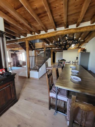 uma sala de jantar com uma grande mesa de madeira e cadeiras em Villa Rural Casa Alma em Castiltierra