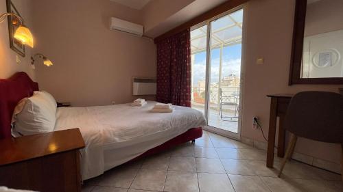 a hotel room with a bed and a large window at Hotel Atlanta in Patra