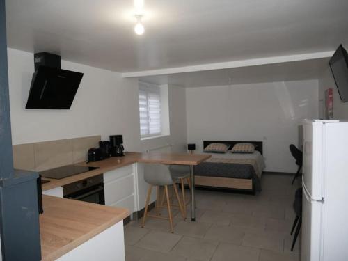 a room with a kitchen and a bedroom with a bed at Studio Indépendant, au calme. in La Roche-sur-Yon