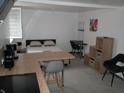 a room with a bed and a table and chairs at Studio Indépendant, au calme. in La Roche-sur-Yon