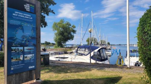 a sign next to a marina with boats in the water at Vänerport Lakefront Hotell in Mariestad