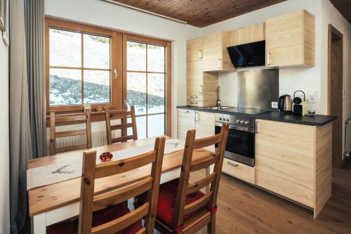 a kitchen with a table and chairs and a kitchen with a stove at Apart Piz Lad in Nauders