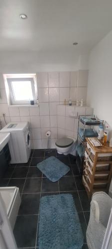 a bathroom with two blue rugs on the floor at Ferienwohnung Sonnenschein in Lünen