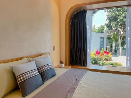 a bedroom with a bed and a window with flowers at Sea House Hotels and Apartments in Vung Tau