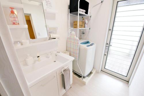 W łazience znajduje się umywalka, toaleta i lustro. w obiekcie ニア・ヤコモ 