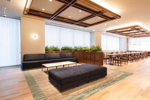 a meeting room with tables and couches and a tableasteryasteryasteryasteryastery at Sotetsu Fresa Inn Yodoyabashi in Osaka