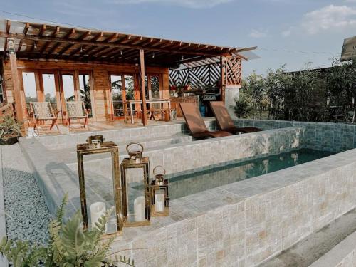 a swimming pool with two candles next to a house at Rancho Oco Pinewood Villa with Swimming Pool in Nasugbu