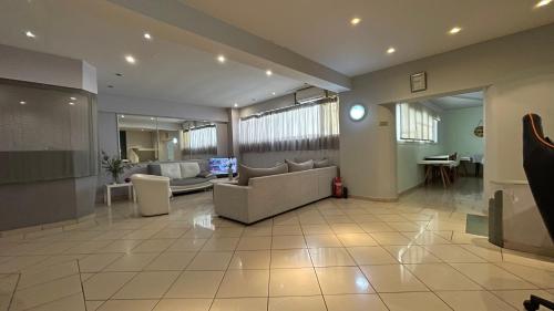 a large living room with couches and a tv at Hotel Atlanta in Patra