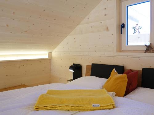 ein Schlafzimmer mit einem Bett mit einer gelben Decke darauf in der Unterkunft Ferienhäuser Stiva Pintga 