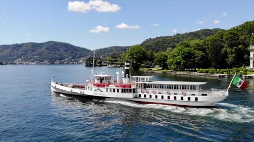 a ferry boat in the water on a river at Alexandra's Sunset Apartment in Domaso