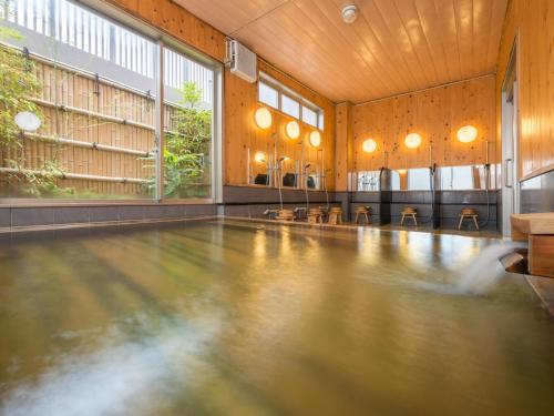 an empty swimming pool in a large room with windows at Hotel Palm Spring in Iwaki