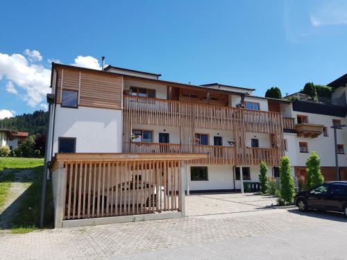 un edificio con una puerta de madera y un coche aparcado delante en Apartment Bergzauber en Reith im Alpbachtal