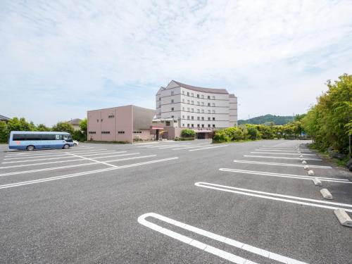 an empty parking lot with a bus parked in front of a building at Hotel Palm Spring in Iwaki