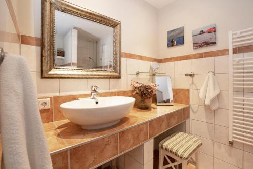 La salle de bains est pourvue d'un lavabo et d'un miroir. dans l'établissement Lenster Möwennest, à Lenste