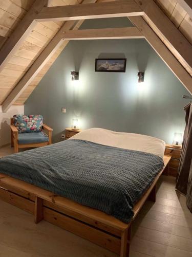 une chambre avec un grand lit dans un grenier dans l'établissement Le Buron des Loups, à Soulages-Bonneval