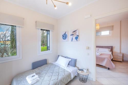 a white bedroom with a bed and a window at Kanali Hill Apartment in (( Agía Eleoúsa ))