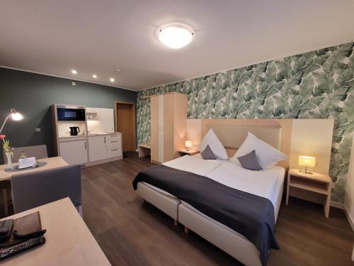une chambre d'hôtel avec un lit et une cuisine dans l'établissement Hotel Pieper-Kersten, à Bad Laer
