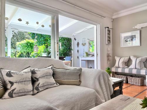 a living room with a couch and a large window at Monique's Place Plett in Plettenberg Bay
