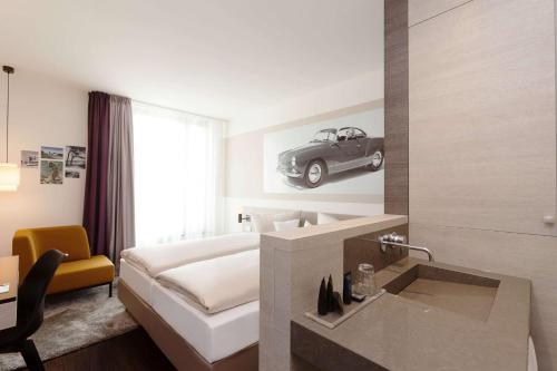a hotel room with a bed and a car on the wall at Vienna House Easy by Wyndham Osnabrück City & Apartments in Osnabrück