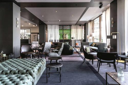 einen Salon mit Sofas, Tischen und Stühlen in der Unterkunft Vienna House by Wyndham Diplomat Prague in Prag