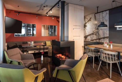 a restaurant with a fireplace and tables and chairs at Vienna House Easy by Wyndham Bremen in Bremen