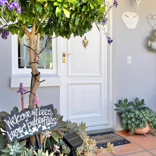 a welcome sign in front of a door with plants at Monique's Place Plett in Plettenberg Bay