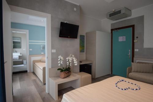 a bedroom with a bed and a living room at Hotel Colombo in Lido di Jesolo