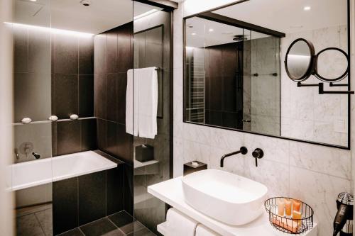 a bathroom with a sink and a mirror at Vienna House by Wyndham Mokotow Warsaw in Warsaw