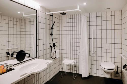 a bathroom with a sink and a toilet and a shower at Vienna House by Wyndham Mokotow Warsaw in Warsaw
